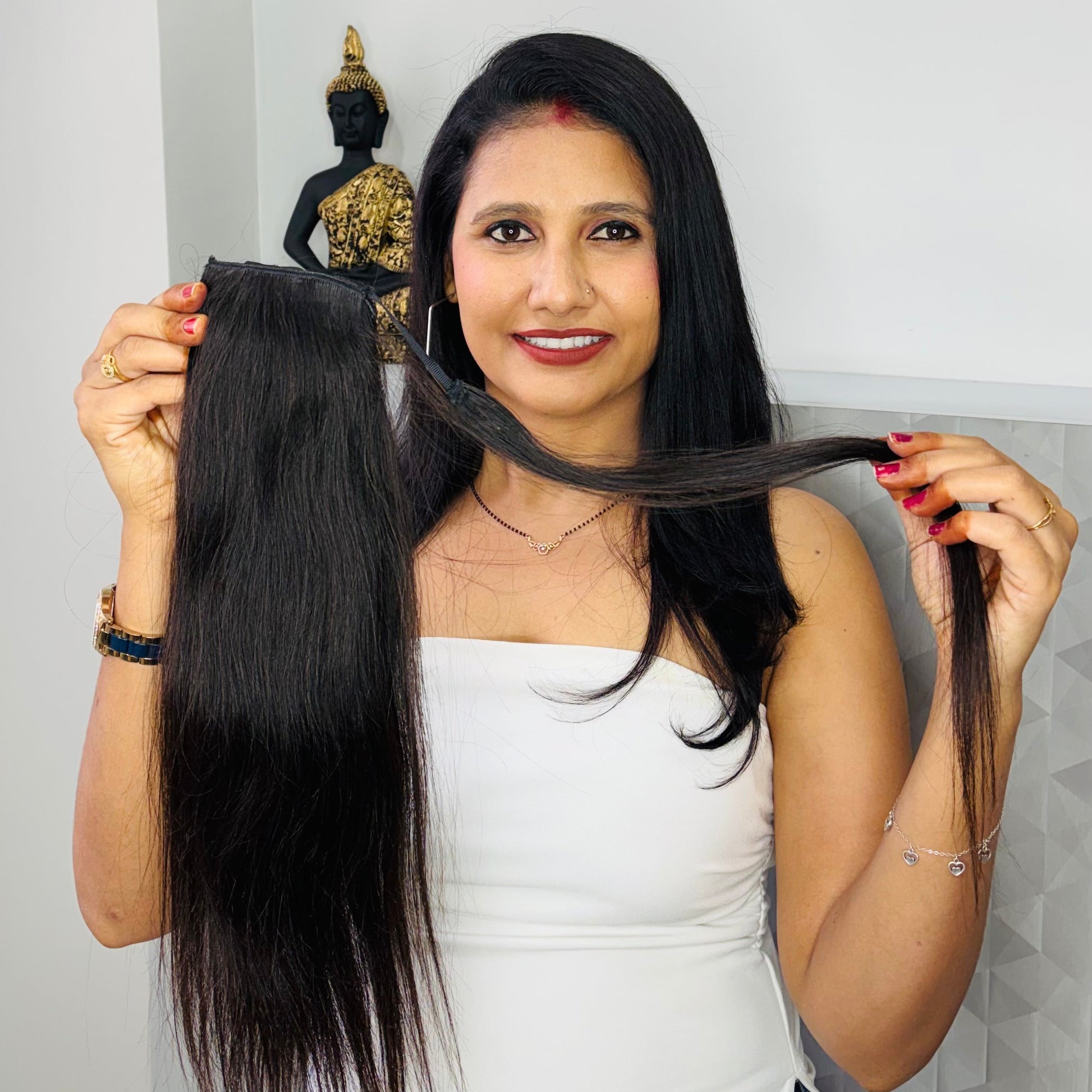 Woman holding a hair extension with a plain background