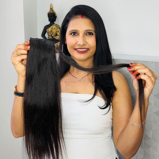 Woman holding a hair extension with a plain background