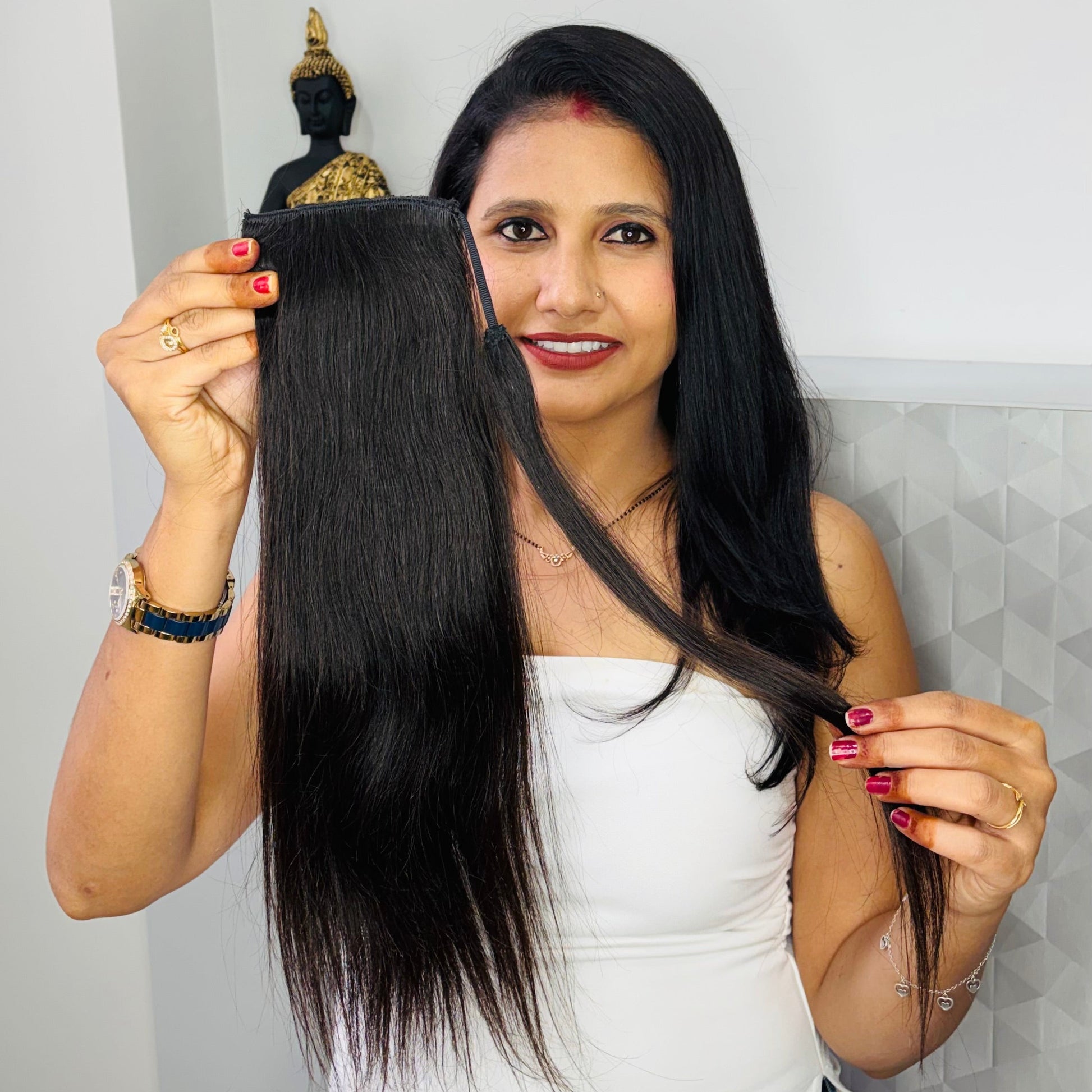 Woman holding a hair extension with a plain background