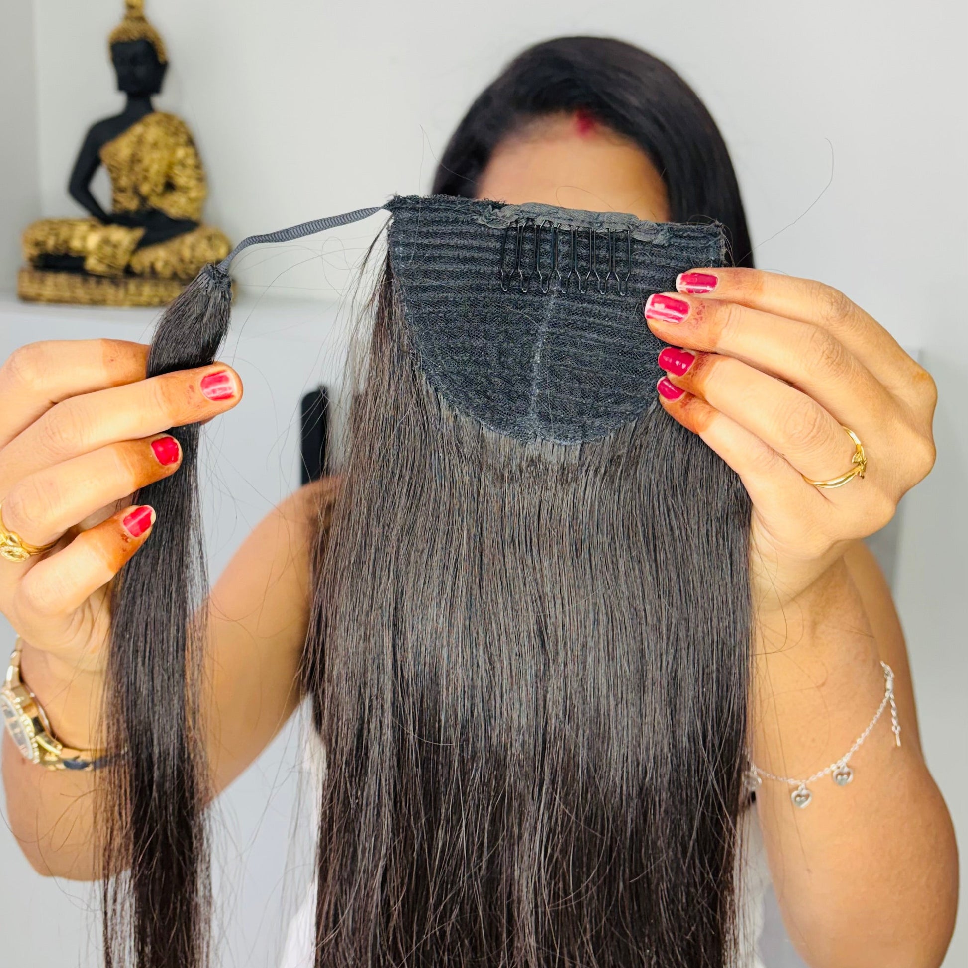 Person holding a hair extension with a plain background