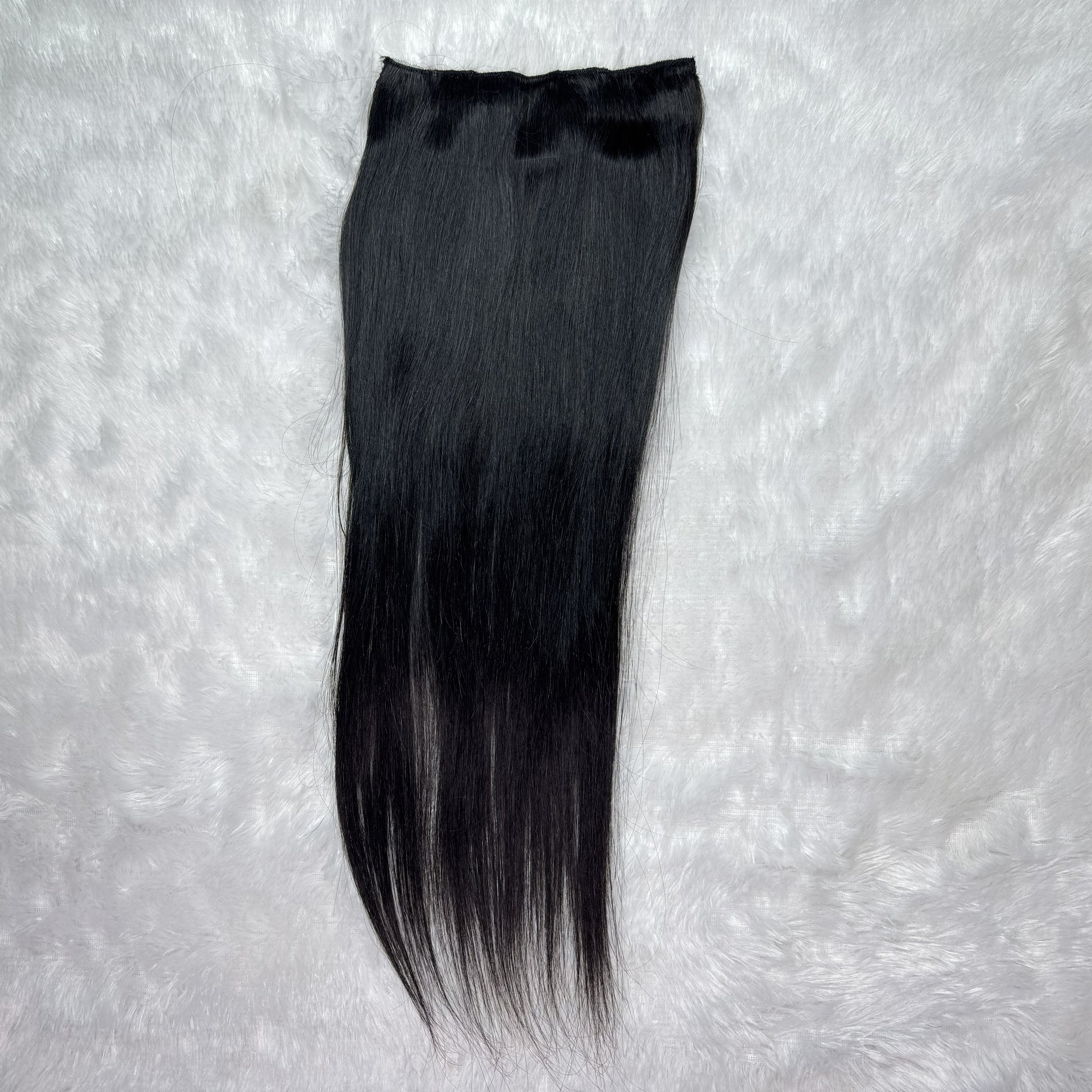 Black hair extension on a textured gray background