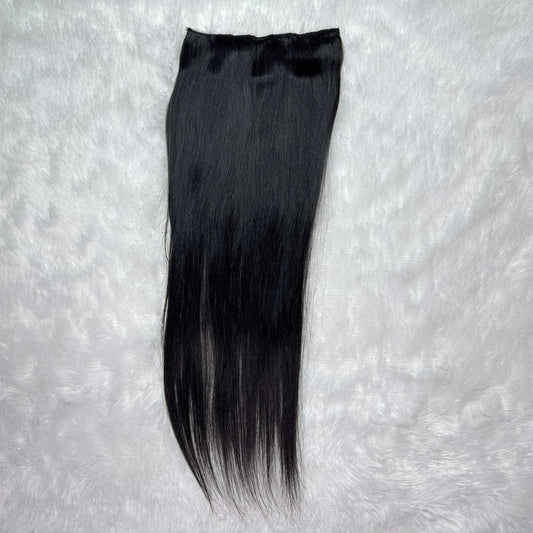 Black hair extension on a textured gray background